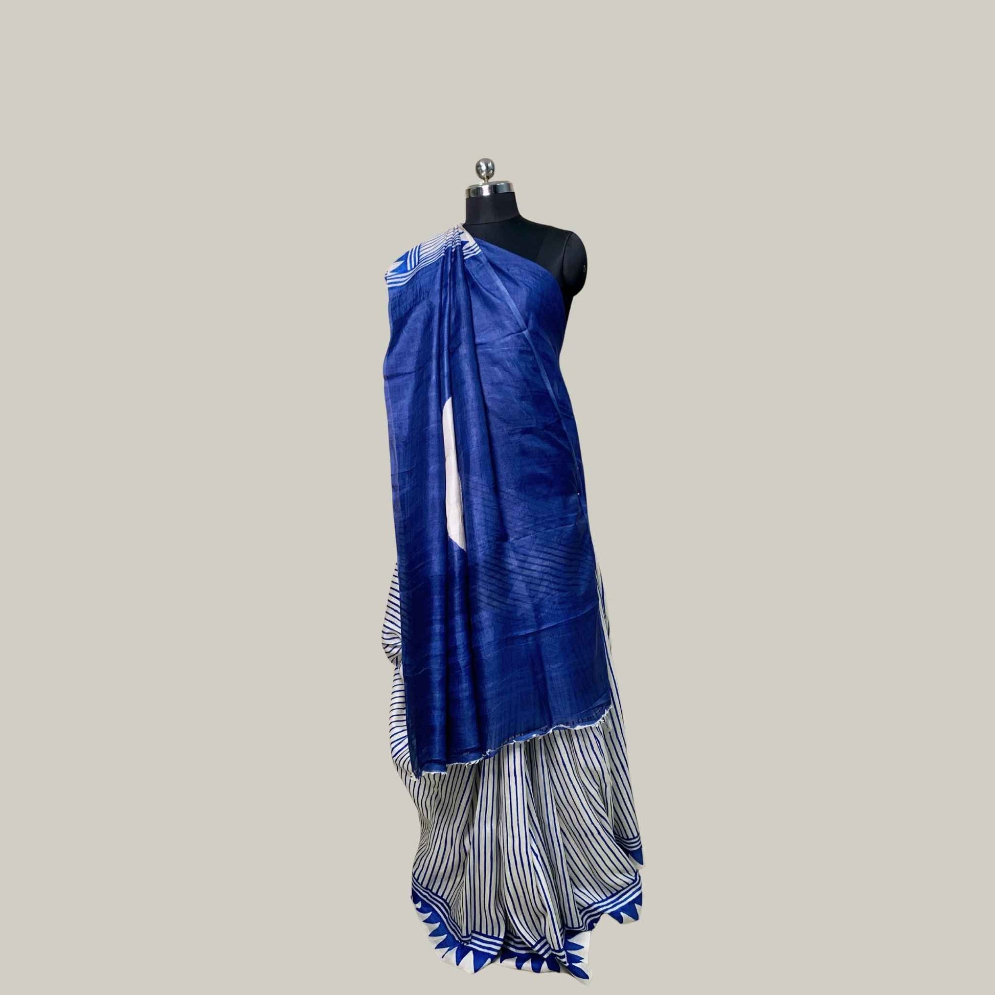 A blue and white striped saree draped on a black mannequin torso against a solid light gray background.