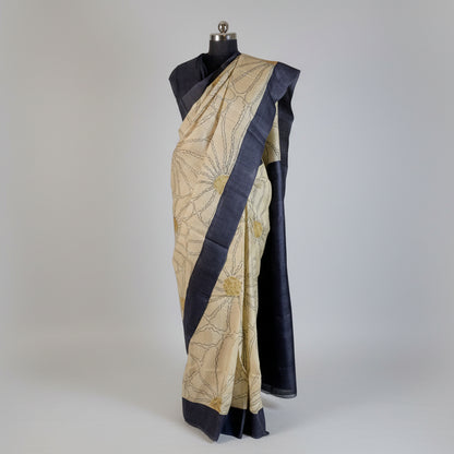 Sari with a blue border on a mannequin against a black background