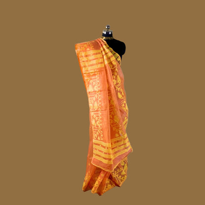 Orange and yellow saree on a mannequin against a brown background