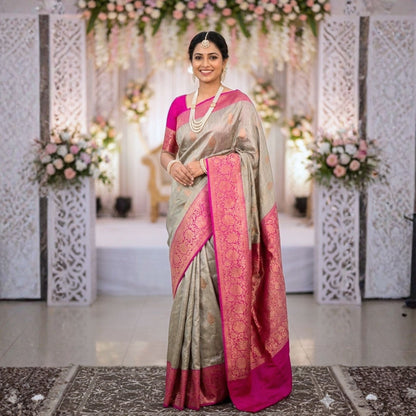 Woman in a traditional saree standing in a decorated indoor setting with floral arrangements.