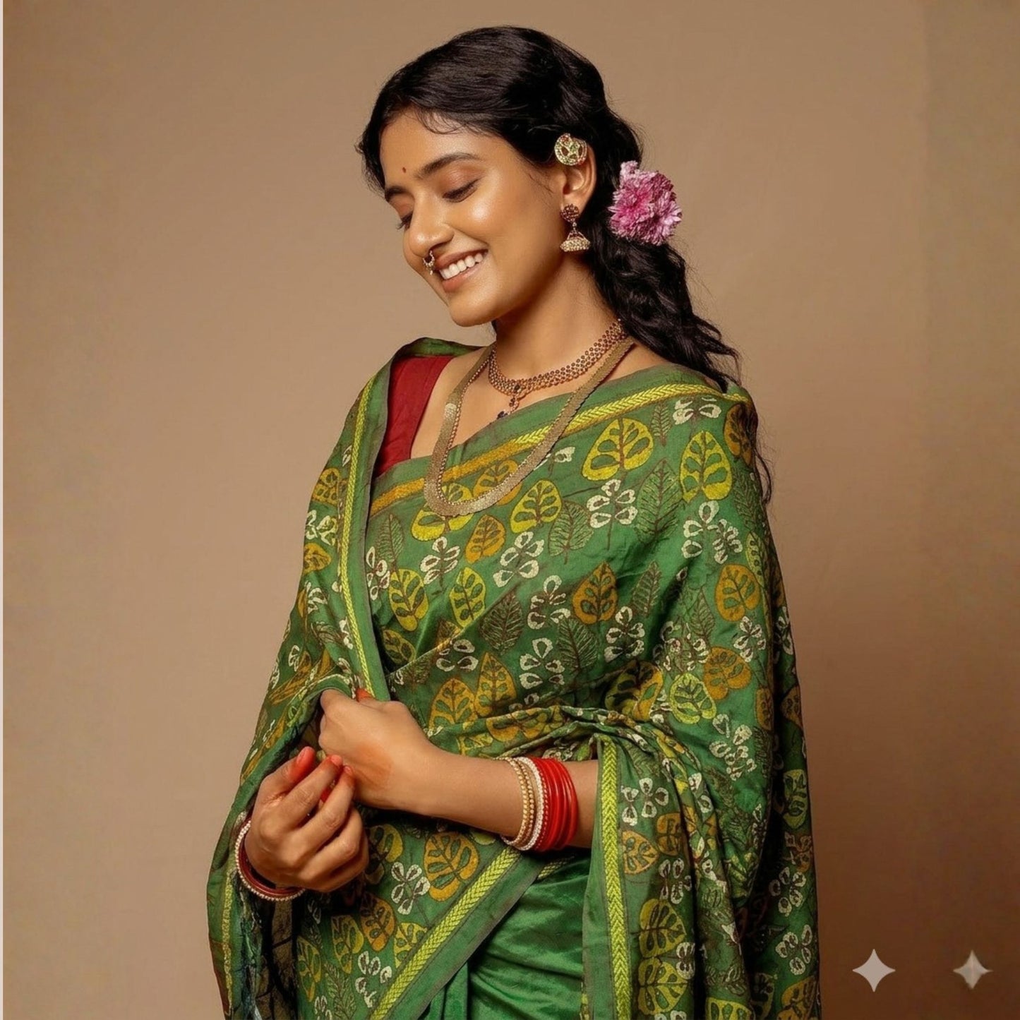 Woman wearing a green saree with a floral design on a beige background